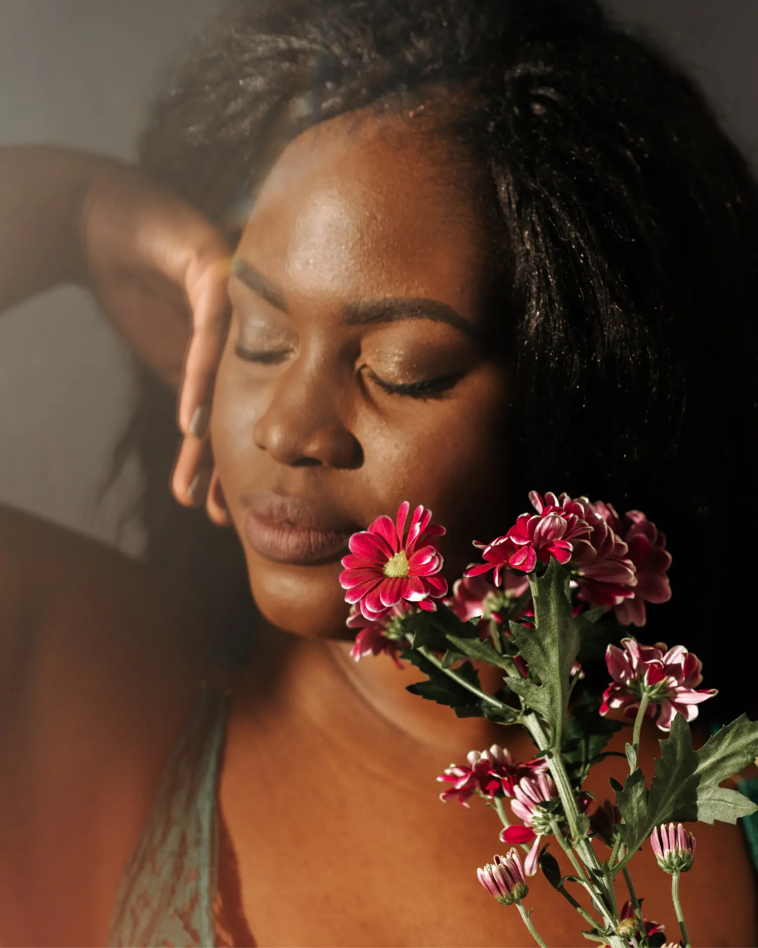 Portrait méditatif de Gassira Tanaba auprès de fleurs, illustrant l’écoute intuitive